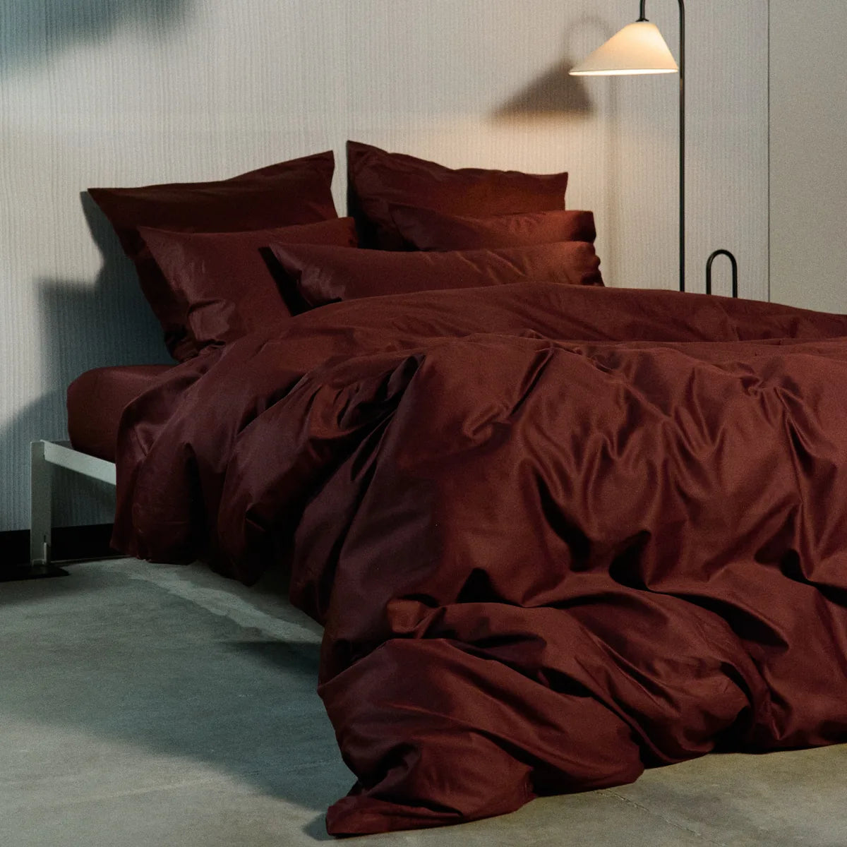 Burgundy bedspread cover on a king-size bed